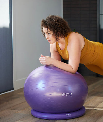 Woman balancing on on purple balance ball
