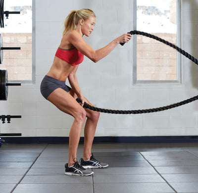 Woman swinging battle ropes up and down