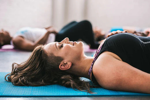 Woman laying in savasana in yoga class
