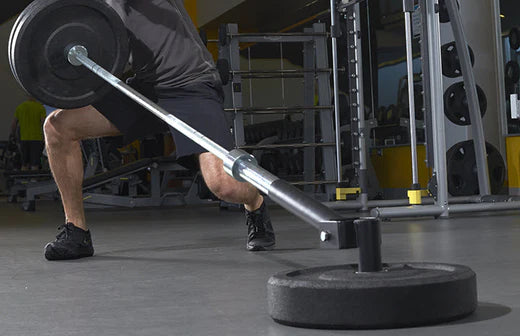 man lifts up heavy bar with weights for landmine athletic conditioning workout