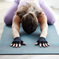 Person in Childs Pose wearing the Gaiam Grippy Yoga Gloves