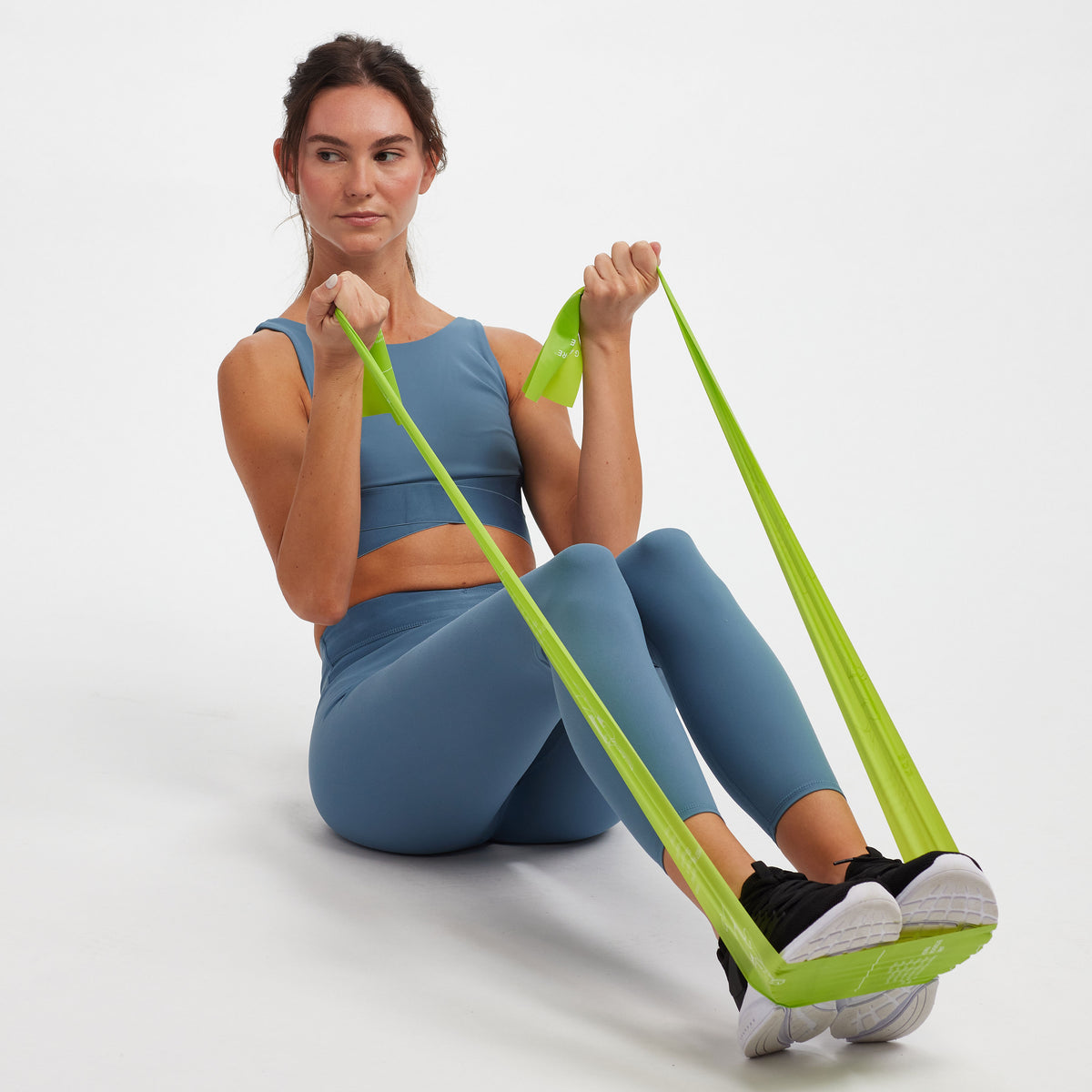 Person seated on the floor - band from the Restore Strength & Flexibility Kit wrapped around the feet  while being held in each hand pulling towards the torso.