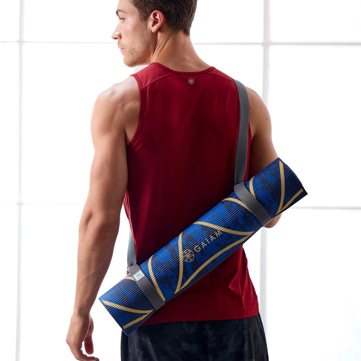 Person wearing/carrying a yoga mat using the Gaiam Easy-Cinch Yoga Sling - person standing with back facing the pose