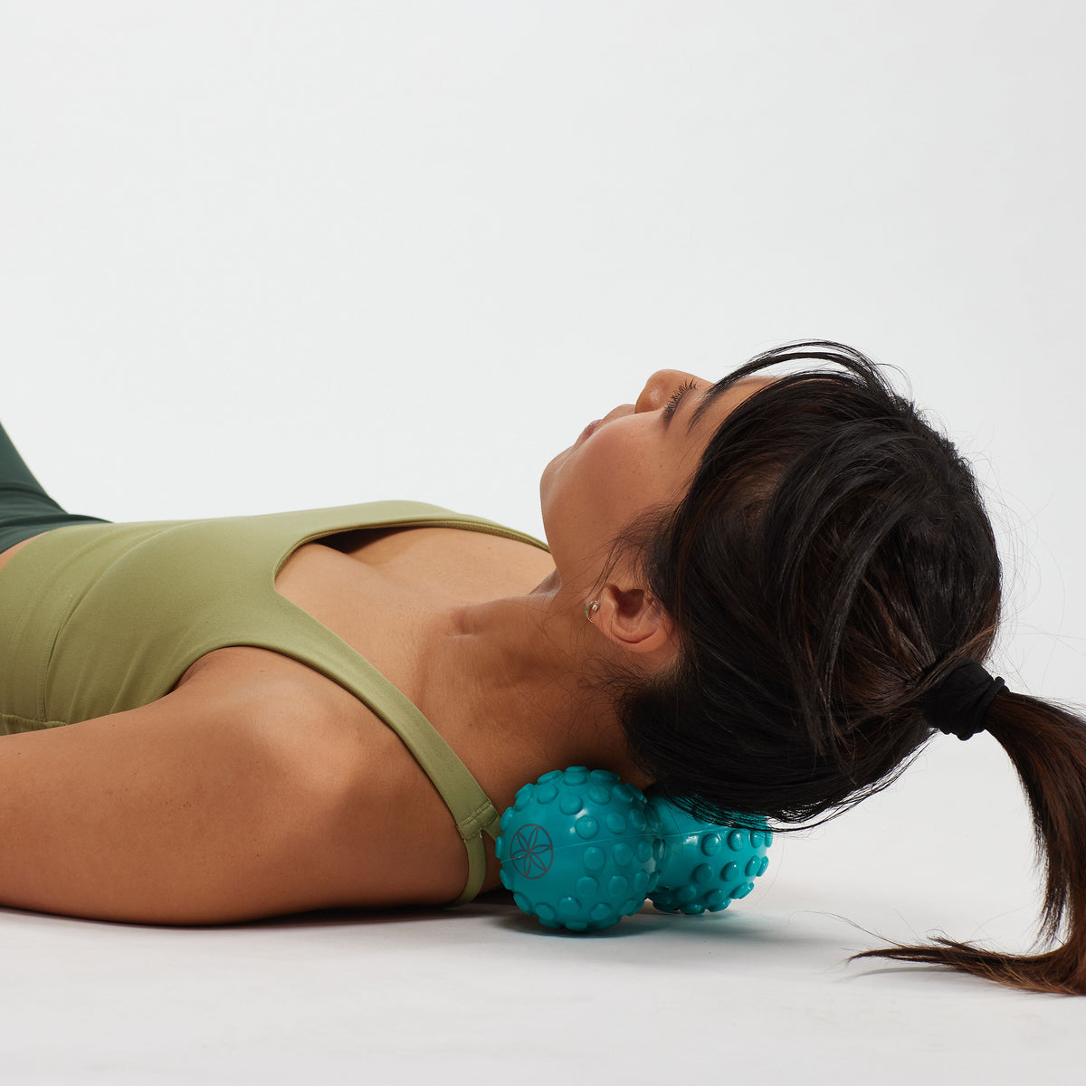 Person laying on the floor with the Restore Dual Zone Back Roller under the neck