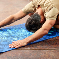 Person in Childs Pose on the Premium Reversible Divine Impressions Yoga Mat