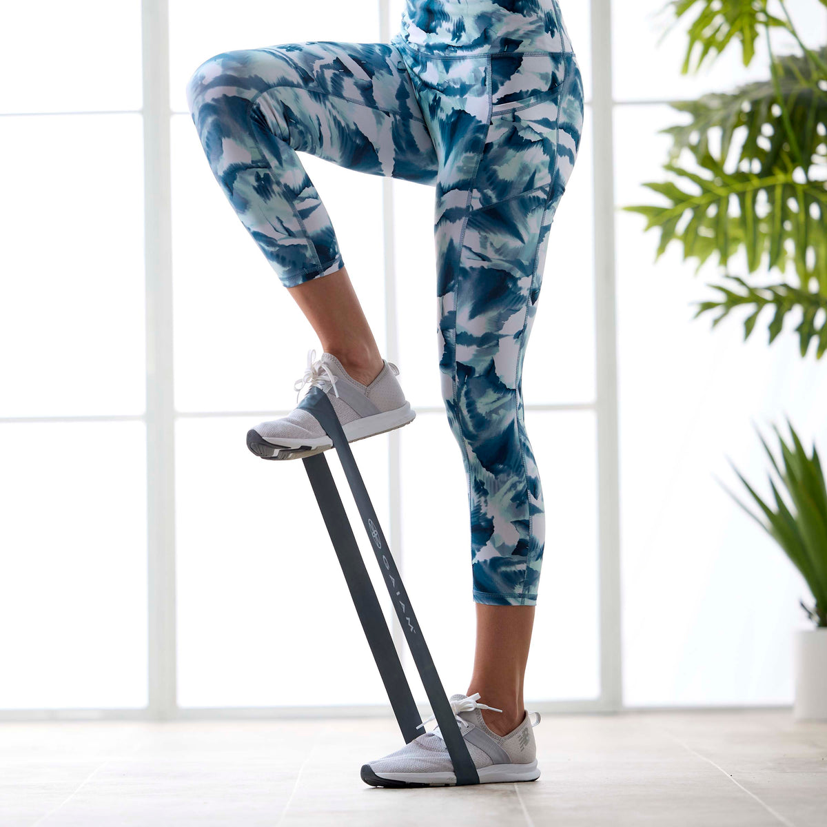 Up close image of person doing a high step with a Restore Mini Band under the foot that is on the ground as well as the foot that is in the high step.