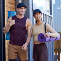 Man and woman wearing hats holding fitness mats