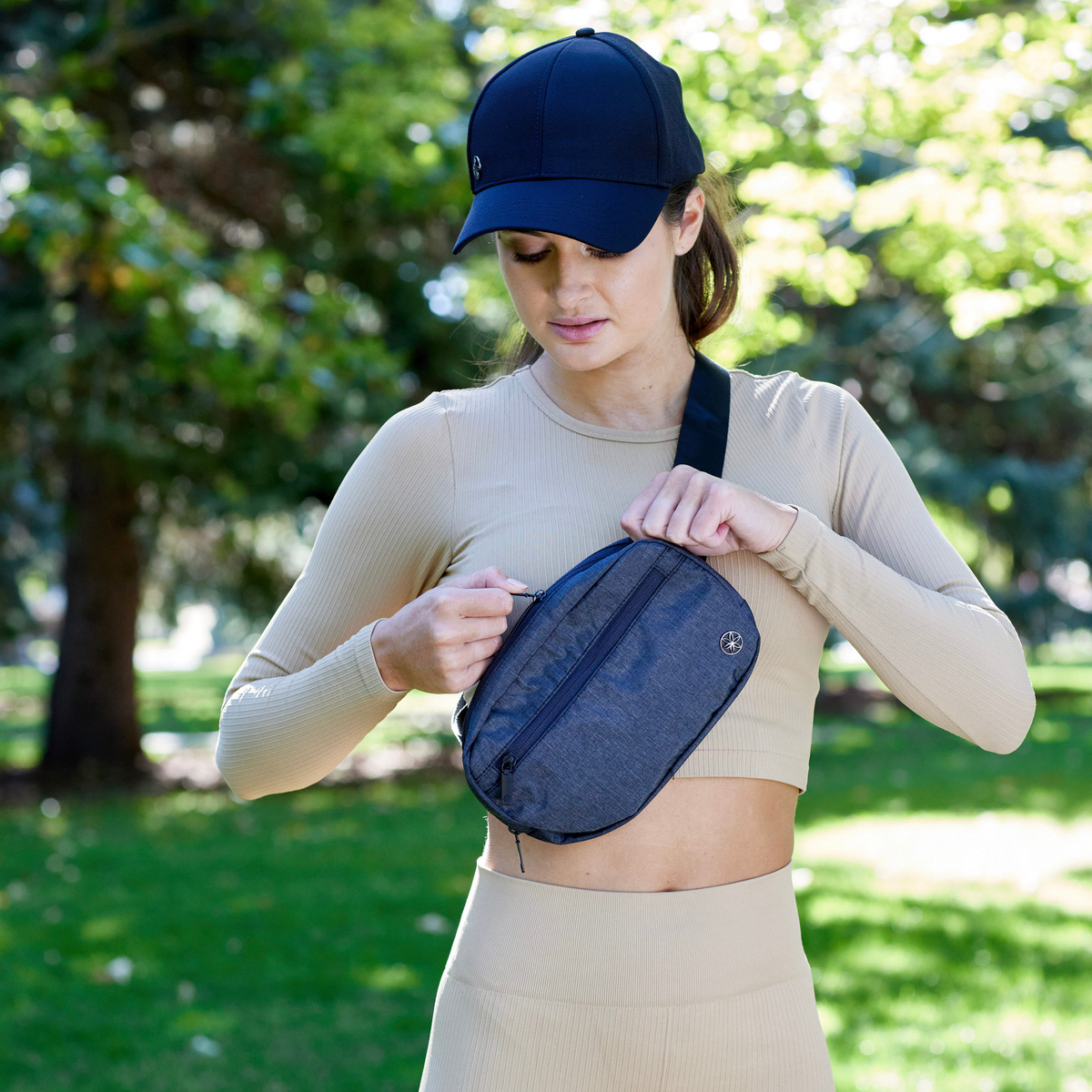 Woman wearing black hat and Get Moving Waist Pack around shoulders