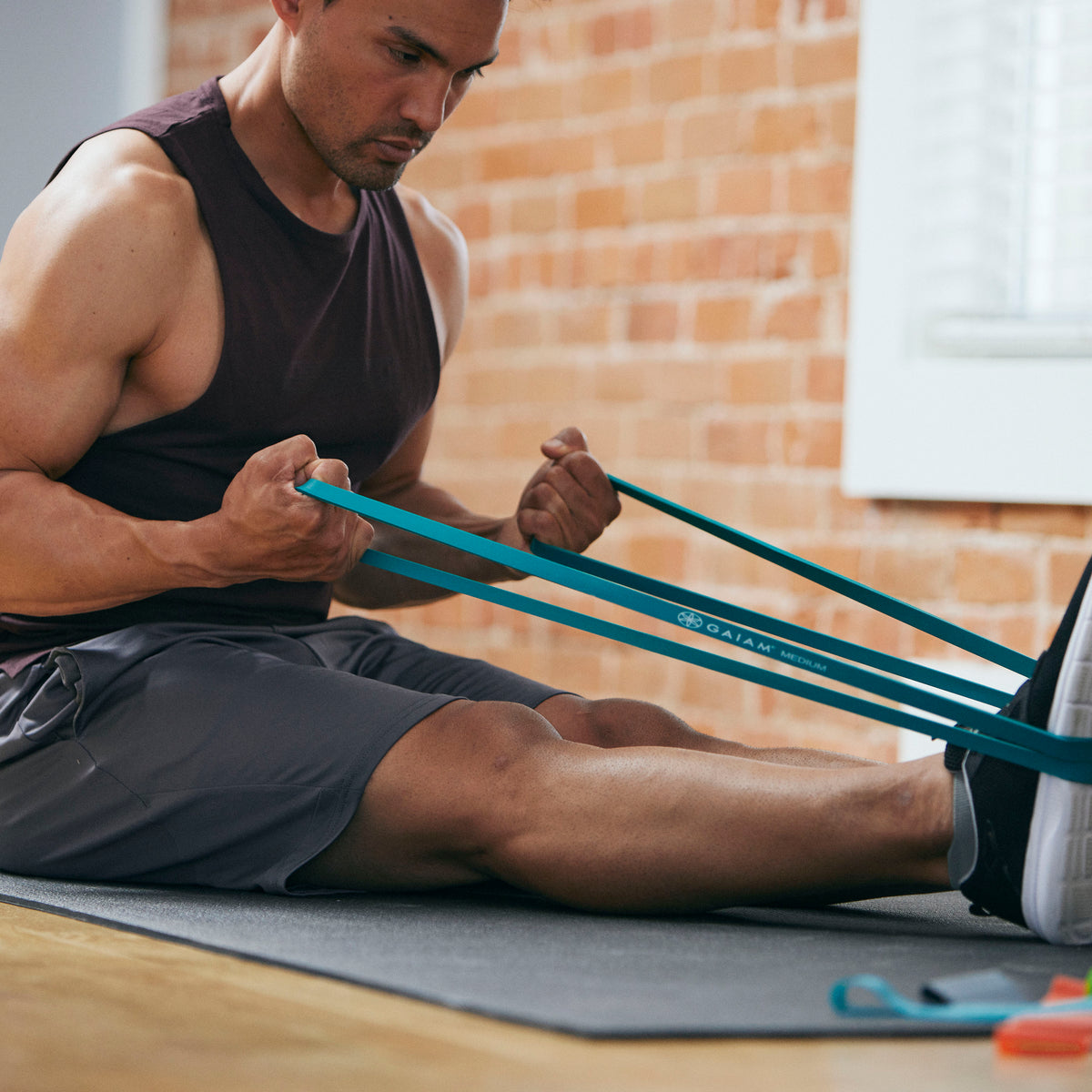 Person seated with the Restore Resistance Training Band around the feet 