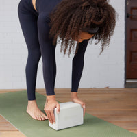 Yoga block being used to support in a front bend