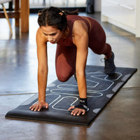 Person wearing the Compression Wrist Sleeve while on fitness mat in a  Mountain Climber pose 