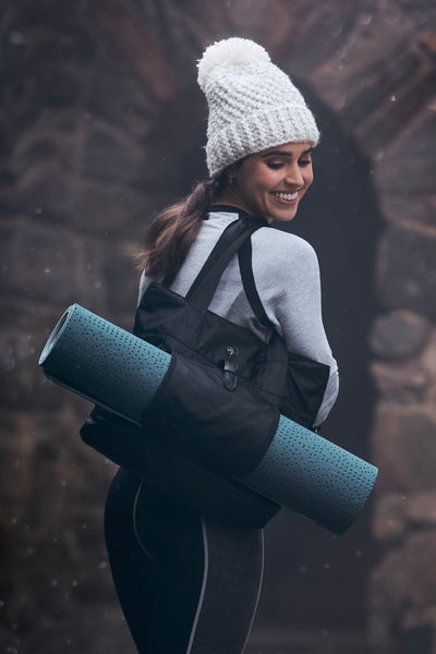 Woman holding bag with a yoga mat inside