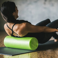Lower back massage with the green Restore Muscle Therapy Foam Roller