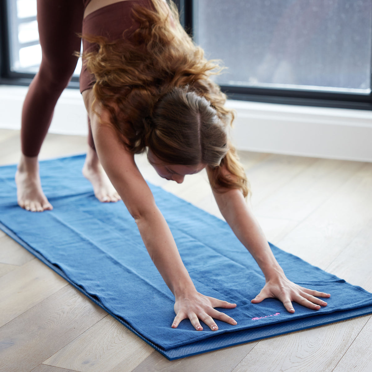 Woman in downward dog on Grippy Yoga Mat Towel