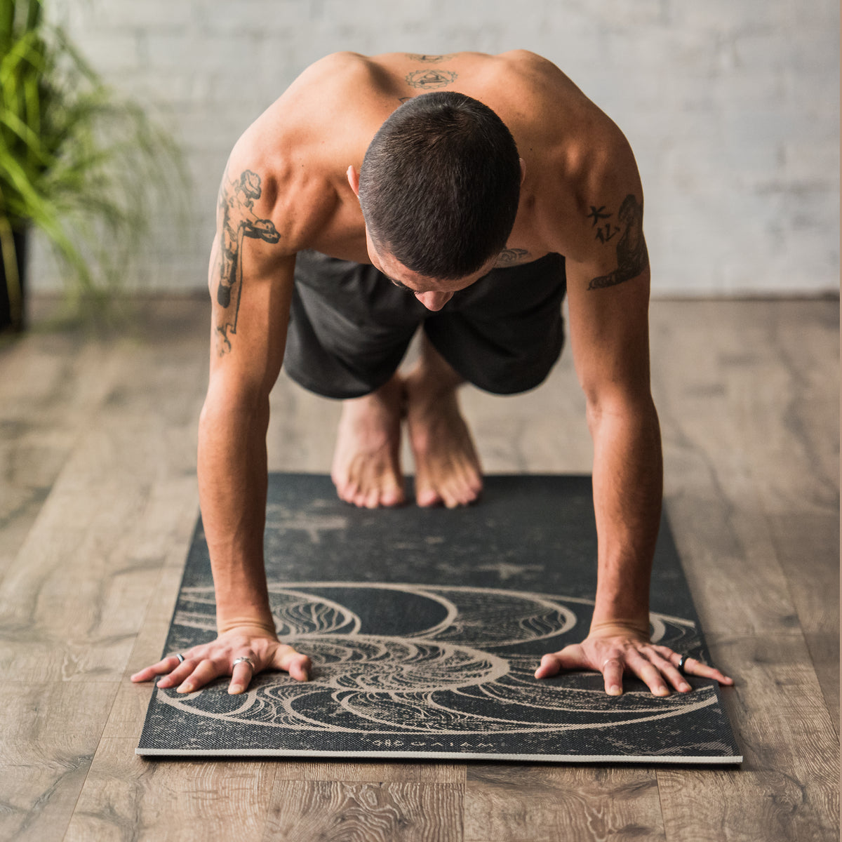 Man doing a plank on Reversible Spiral Motion yoga mat
