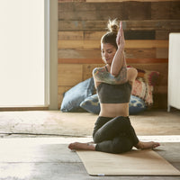 woman in seated eagle pose on cork yoga mat