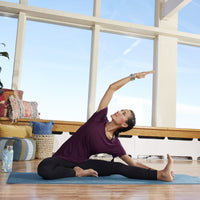 woman doing side stretch on jute yoga mat