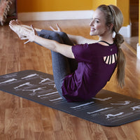 woman holding boat pose on fitness mat
