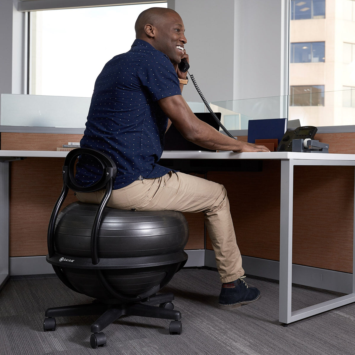 man sitting on ultimate balance ball chair at an office desk