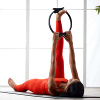 Woman on floor doing hamstring stretch with Pilates Ring