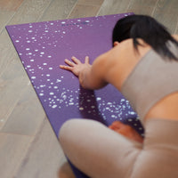 Person bending over yoga mat 