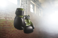 green and black boxing gloves hanging