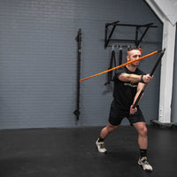man using Stroops Slastix® Clip Resistance Band attached to wall