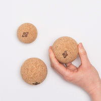 Person holding one of the three cork massage balls.