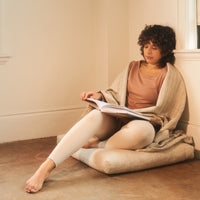 Halfmoon Melange Cotton Yoga Blanket draped around woman's shoulders