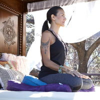 Woman Meditating on Blue Zafu Cushion on Purple Zabuton Floor Cushion