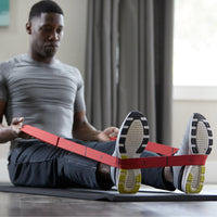 man using the resistance band stretch strap around feet